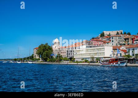 Esplorando la storica città vecchia di Sibenik lungo il lungomare in Croazia con barche ed edifici Foto Stock
