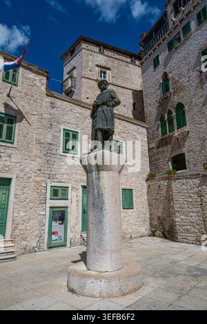Statua di fronte agli edifici storici vicino alla cattedrale di San Giacomo a Sibenik, Croazia, in una giornata di sole Foto Stock
