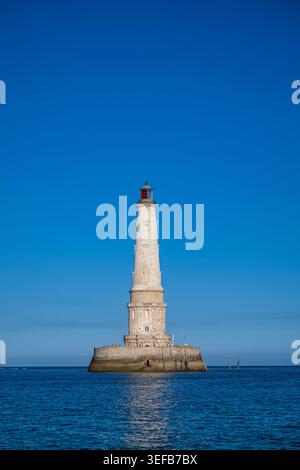Il faro di Cordouan si erge alto nell'oceano sotto il cielo blu Foto Stock