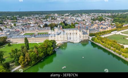 Esplora il Palazzo Fontainebleau dall'alto, con i suoi giardini e la sua architettura lungo le tranquille acque e l'area circostante in Francia Foto Stock