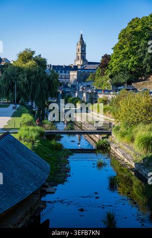 I visitatori possono godersi una giornata di sole sul fiume in una città francese con edifici storici e alberi sullo sfondo Foto Stock