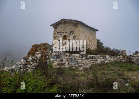 Esplora un'antica necropoli nella regione del Caucaso dell'Ossezia settentrionale, in Russia, in una giornata nebbiosa Foto Stock