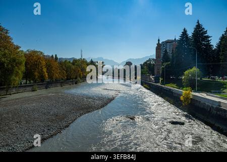 Il fiume Terek scorre attraverso Vladikavkaz con edifici e alberi sulle rive Foto Stock