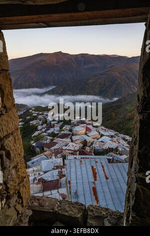 Vista da un punto panoramico in pietra che mostra la città di Kubachi nel Daghestan, Russia, con tetti e montagne in lontananza Foto Stock