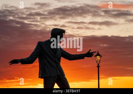 La statua di Billy Fury si erge al tramonto su un cielo colorato a Liverpool presso il Royal Albert Dock Foto Stock