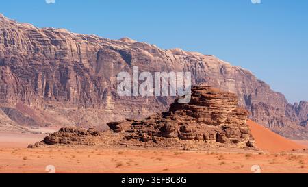Esplorando il terreno desertico di Wadi Rum con formazioni rocciose e un cielo azzurro brillante in Giordania Foto Stock