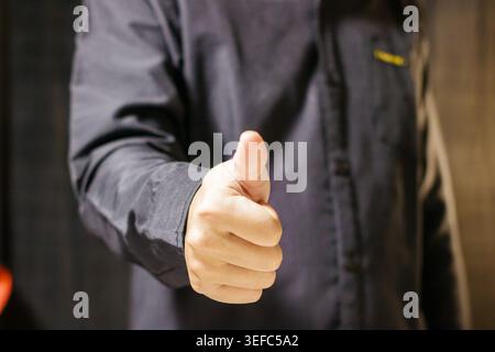 Uomo che mostra un gesto con i pollici in alto. Gesto dell'accordo. Concetto di business. Linguaggio del corpo. Foto di alta qualità Foto Stock