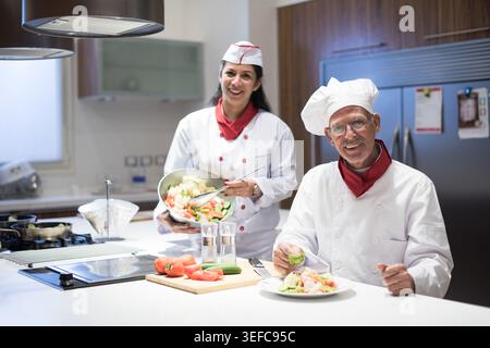 Chef della famiglia mediorientale che preparano insieme la cena iftar Eid Ramadan in una moderna cucina casalinga Foto Stock