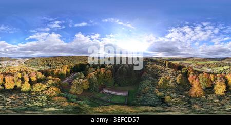 Vista panoramica delle fondamenta in pietra e delle strutture ricostruite del Tempio Romano di Tawern in mezzo al bosco autunnale in Germania. Foto Stock