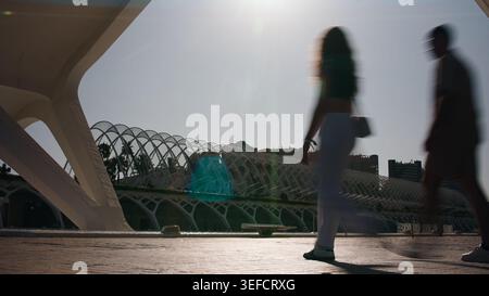Le persone che camminano si offuscano in movimento sotto la moderna tettoia architettonica al sole di valencia Foto Stock