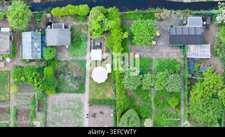 Veduta aerea dell'Associazione Amateur Gardeners Het Kloosterpark con rigogliosi appezzamenti verdi, piccoli capannoni, serre e un ombrellone bianco a De Bilt, Ut Foto Stock