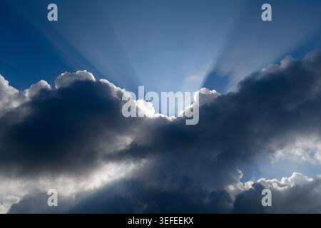 Vista aerea di raggi luminosi del sole che si infrangono attraverso nuvole di tempesta scure contro un cielo blu a Klobouky u Brna, Jihomoravsky kraj, Cechia. Foto Stock