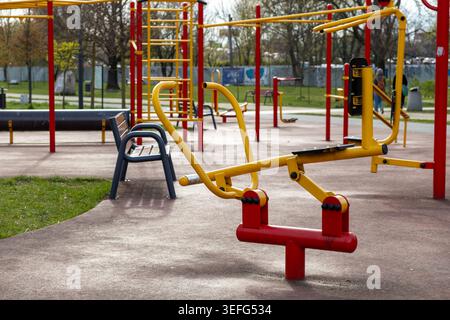 Palestra pubblica vuota nel parco con macchine fitness, che offre accesso gratuito all'esercizio all'aperto, all'allenamento fisico e alla promozione della salute a urba Foto Stock