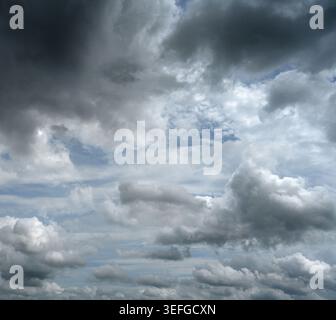 Per lo più cielo nuvoloso con nuvole di tempesta negli angoli superiori e piccole macchie sparse di cielo blu Foto Stock