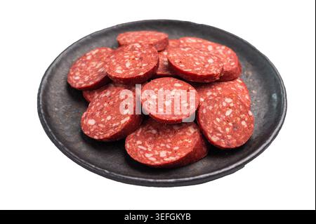 Sucuk turco intero e a fette (sujuk) con timo su un piatto nero. Salsiccia piccante e stagionata, isolata su bianco Foto Stock