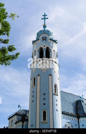 Vista della torre della Chiesa Blu Art Nouveau con il suo caratteristico orologio e la facciata blu sotto un cielo limpido a Bratislava, regione di Bratislava, Slovacchia. Foto Stock
