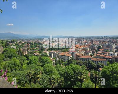 Vista panoramica sui tetti in terracotta della bassa Bergamo verso le Alpi da Bergamo alta, Lombardia, Italia Foto Stock