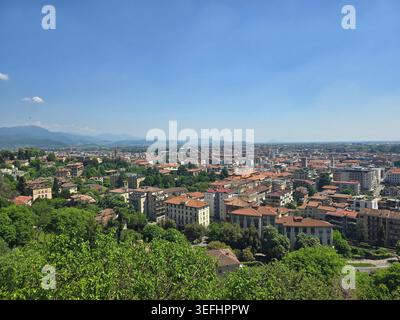Ampia vista panoramica sui tetti della bassa Bergamo verso le colline alpine da Bergamo alta, Lombardia, Italia Foto Stock