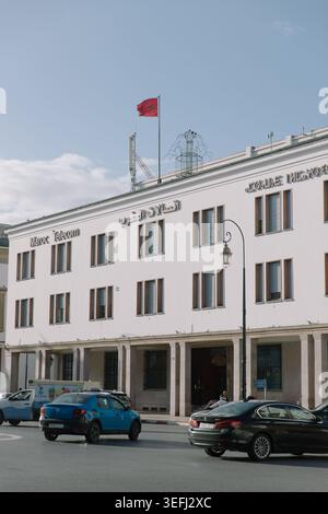 Una bandiera del Regno del Marocco ondeggia nel vento in cima a un edificio appartenente al fornitore di telecomunicazioni Telecom Maroc di Rabat. Foto Stock