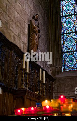 Statua religiosa, vetrata colorata e candele di preghiera all'interno della cattedrale di Notre Dame a Parigi, Francia, il 9 agosto 2017. Foto Stock