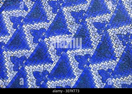 Vista ravvicinata di un pavimento a mosaico antico con motivi colorati e messa a fuoco selettiva. Piastrelle lavorate a mano in giallo, marrone, blu, verde, rosso, an Foto Stock