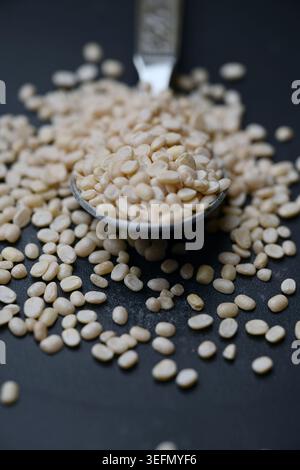 Split Urad dal in Spoon, Macro cibo Angled Top View su sfondi scuri defocati con illuminazione spettacolare Foto Stock
