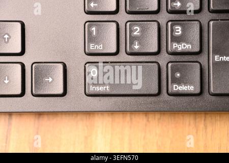 Foto macro della tastiera nera del computer evidenziando 0 e inserire i tasti sul tastierino numerico con sfondi morbidi sfocati Vista dall'alto Foto Stock