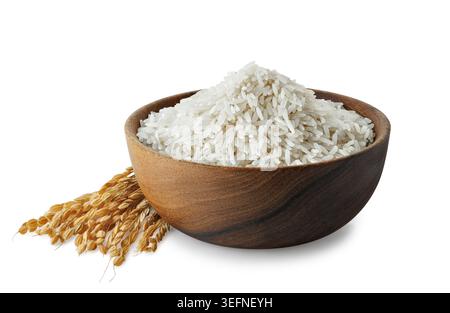 Grani di riso bianco in una ciotola rustica di legno con gambi di riso asciutti isolati su sfondo bianco Foto Stock