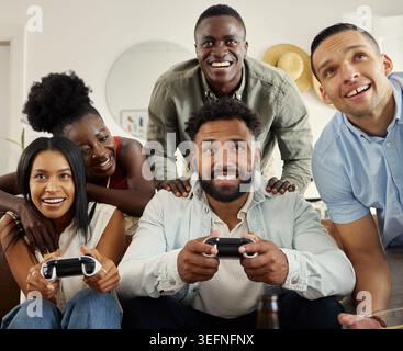 Videogiochi, Happy e amici sul divano con controller per l'incollaggio, il relax e il divertimento per le riunioni sociali. Gaming, eccitato e persone sul divano per Foto Stock