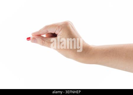 La donna di mezza età contiene pillole rosse e bianche isolate su bianco Foto Stock