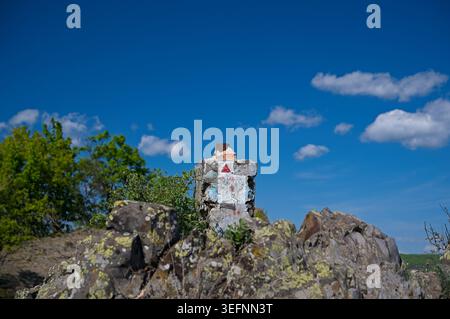 Segnaletica rossa del triangolo dipinto su un palo di cemento nella formazione rocciosa Boszorkany-ko vicino al castello di Salgo. Foto Stock