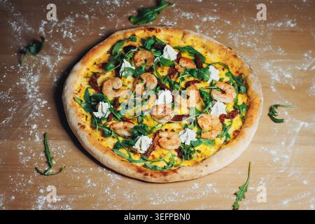 Deliziosa pizza ai gamberi condita con spinaci e formaggio Foto Stock