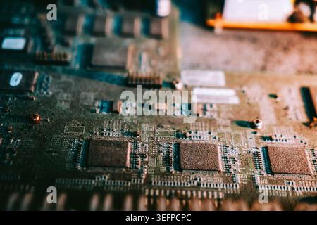 Una vista ravvicinata di una scheda a circuito elettronico dettagliata con più chip, microcomponenti, collegamenti saldati e circuiti complessi per el Foto Stock