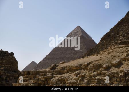 Piramidi di Giza che si innalzano sopra le rovine del deserto in Egitto Foto Stock