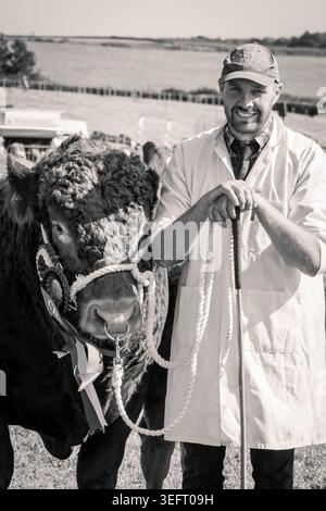 John Tucker, di East Prawle, Devon, con il suo premio Red Devon Bull, al South Devon Show, 2025 Foto Stock
