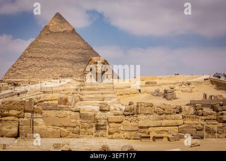 La grande Piramide di Giza (Piramide di Cheope) e la grande Sfinge di Giza vista panoramica, turisti intorno all'Egitto. Foto Stock