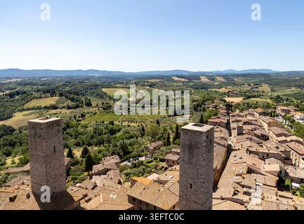 vista sui tetti di san gimignano, toscana, verso la campagna con campi e oliveti, giorno di sole Foto Stock