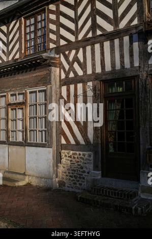 Antiche case in legno a Beuvron-en-Auge, un insediamento di punta nel paese del sidro Pays d'Auge di Calvados, bassa Normandia, Francia. Il villaggio, un tempo di proprietà della famiglia anglo-francese Harcourt, ha case padronali in legno e case ben conservate risalenti al XVI-XVIII secolo. È ufficialmente classificato come uno dei più bei villaggi francesi. Foto Stock