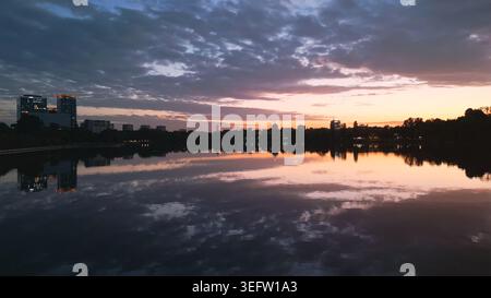 Il paesaggio urbano di Bucarest si riflette nel lago herastrau Park al tramonto Foto Stock