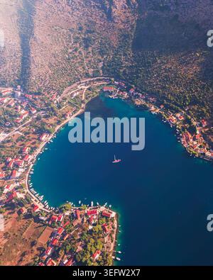 Vista aerea di un villaggio con tetti rossi intorno a una tranquilla baia Foto Stock