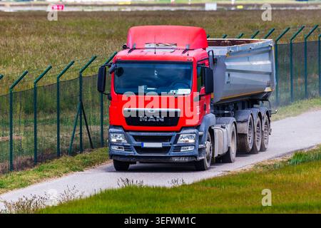 MAN TGS con rimorchio ribaltabile Wielton vuoto su strada sterrata l'8 maggio 2025 a Bratislava, Slovacchia Foto Stock