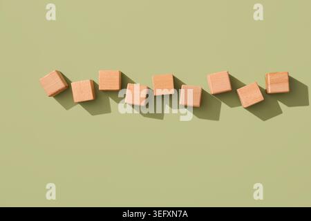 Cubi di legno con INSERIMENTO della parola su sfondo verde Foto Stock