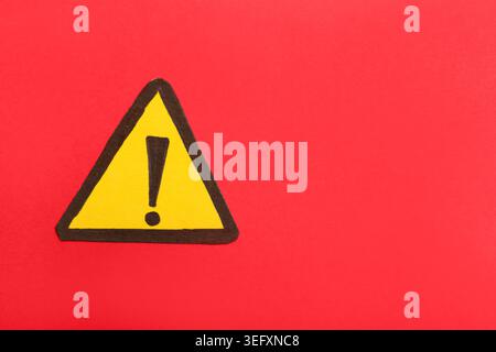 Triangolo giallo con punto esclamativo su sfondo rosso Foto Stock