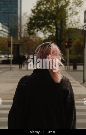 Donna in stile urbano che ascolta musica Foto Stock
