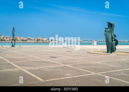 Esterno moderno del Museo Nazionale del Bahrein con sculture e vista dello skyline della città a Manama, capitale del Bahrein Foto Stock