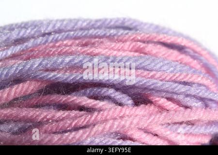 Primo piano di palle in filato di lana rosa e viola su sfondo bianco Foto Stock