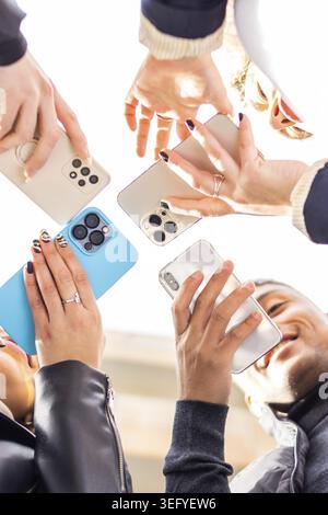 Angolazione ridotta di un gruppo di persone che tiene il cellulare. Angolazione ridotta di un gruppo di persone con smartphone Foto Stock