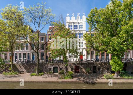 Moli con cantine di banchine, fioritura di castagno rosso e castello cittadino Leeuwenberg con facciata bianca lungo il canale Oudegracht nel centro di Utrecht Foto Stock