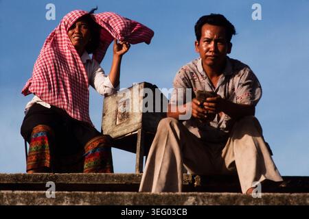 Commercianti di strada con cibo da vendere alla gente che guarda una partita di calcio a Phnom Penh, Cambogia, 1987. Foto Stock