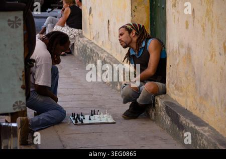 Due uomini cubani che giocano a scacchi su un marciapiede in una strada dell'Avana Foto Stock